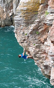 DWS climber on White Rhino Tea (f7a S1), Devon, England. White Rhino Tea Deep Water Solo.jpg