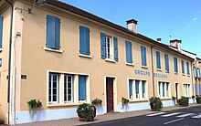 Photographie en couleurs, représentant un bâtiment (une école).