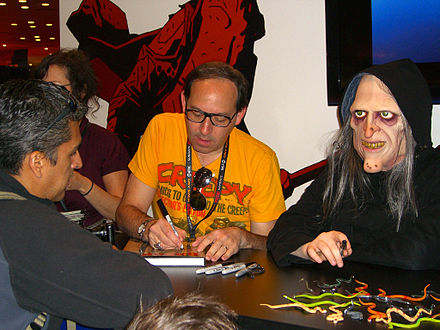 Editor Dan Braun signs a collected edition of Creepy next to a model dressed as Uncle Creepy at the Dark Horse Comics booth at the 2011 New York Comic Con.