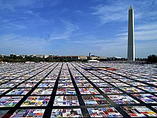 The AIDS Memorial Quilt is pictured as laid out beside the Washington Monument Aids Quilt.jpg