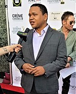 Writer-director Benjamin Bryant is speaking to a journalist on a red carpet at an event