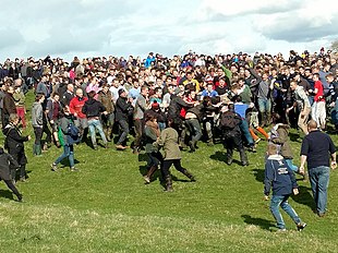 The 2016 game of 'bottle-kicking' in Hallaton, Leicestershire, actually played with three small wooden barrels. One of them can just be seen being held by a man at centre right. Bottle Kicking.jpg