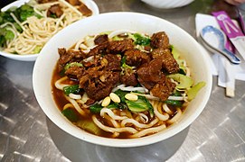 Bowl full of noodles with marinated beef, bok choy, celery and green pea shoots - panoramio.jpg