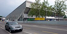 Eingangsseite mit Reihung der Binder, Haupttribüne und dem vom Zugband begrenzten Foyer