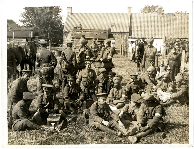 English and Indian soldiers of the Lucknow Cavalry Brigade's Signal Troop relaxing in a farmyard at brigade headquarters, 28 July 1915