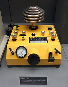 Dead-weight tester. This uses known calibrated weights on a piston to generate a known pressure. Dead weight tester, Type PD23, Nagano Keiki Co., Ltd. - National Museum of Nature and Science, Tokyo - DSC07787.JPG