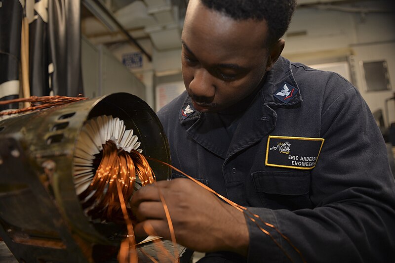 File:Electrician's Mate 3rd Class Eric Anderson rewiring the coils of a motor.jpg