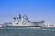 HMS Illustrious escorting the contestants in the 2011 Clipper Round the World Yacht Race to the start line in the Solent.