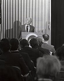 Černobílá fotografie Cousteaua na tiskové konferenci v roce 1973.