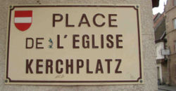 Plaza de la Iglesia: placa bilingüe en Ensisheim.