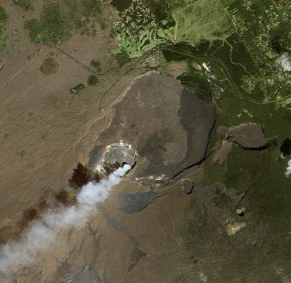 Kīlauea's summit caldera; volcanic gas can be seen rising out of Halemaʻumaʻu, within the caldera (January 2012)