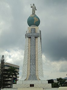 A picture of a monument consisting of a small tower with a globe on top of it with Jesus on top of the globe.