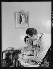 Mr. and Mrs. Frank Romano feeding their baby