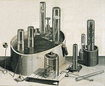 Berbagai peralatan ilmiah, seperti palung pneumatik. Seekor tikus mati ditempatkan di bawah salah satu tabung gelas.