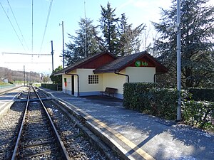 One-story building with gabled roof next to tracks and platforms