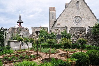 Herbal garden on a small plateau within the castle's fortifications, Liebfrauenkapelle's clock tower and the main facade of the St. John's church in the background