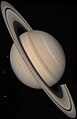 Saturno en veraj koloroj kun la lunoj Tetiso (kiu projekcias sian ombron), Diono kaj Reo.