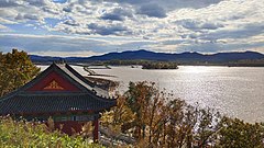 圖為四豐山水庫，近處為龍王廟，水中為湖心島，遠處為四豐山和風力發動機