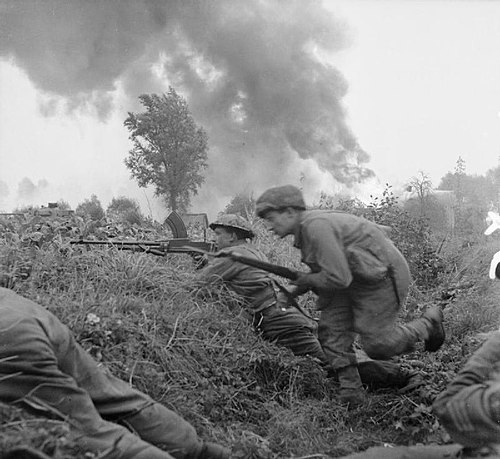 Troops of the 2nd Derbyshire Yeomanry take cover in a ditch during an attack on St Michielsgestel, 24 October 1944.