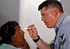 US Navy 070925-N-0194K-183 Hospital Corpsman 2nd Class Mark Andrews, an optician attached to Military Sealift Command hospital ship USNS Comfort (T-AH 20), examines a patient's eyes at Charity Hospital.jpg