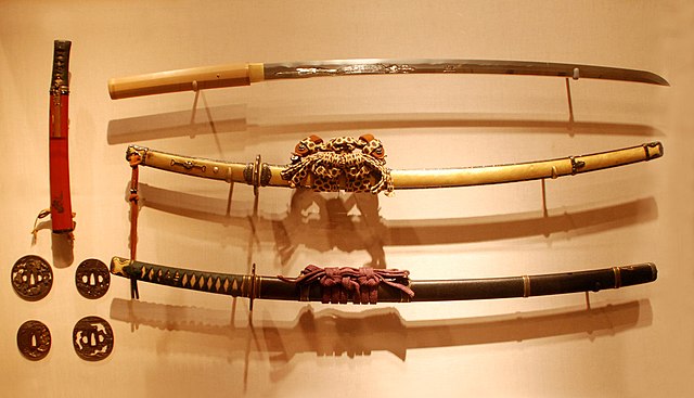 Japanese swords. Two tachi with full mountings (middle and bottom right), a sword with a Shirasaya-style tsuka (top right), a wakizashi (top left), an