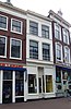 Winkel/woonhuis met drie bouwlagen, gepleisterde lijstgevel, pui uit 1900 met portiek, vier halfzuilen en hoofdgestel en een schilddak (Gouda-Centrum)