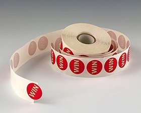 Roll of die-cut pressure-sensitive labels on a release liner "WIN" stickers.JPG