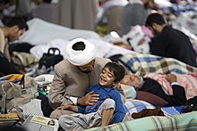 عکس از یک روحانی مسلمان شیعه و فرزندش در مراسم اعتکاف در حرم فاطمه معصومه در شهر قم