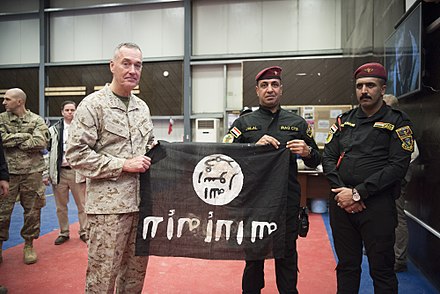 Iraqi soldiers present US Marine General Joseph Dunford with a captured ISIL flag during the intervention.