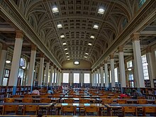 This is a photograph of the Reading Room inside the Barr Smith Library. It features gold and ivory arches, pillars and a high ceiling.