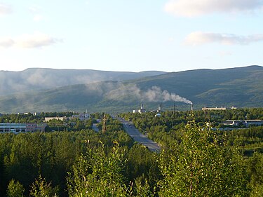 Outskirts of the town Apatity where mining of apatite ore from the Kola alkaline Province is the main economic activity. In the background is the Khibiny Mountains, a giant and protruding body of nepheline syenite. Apatyty na tle Chibin.JPG