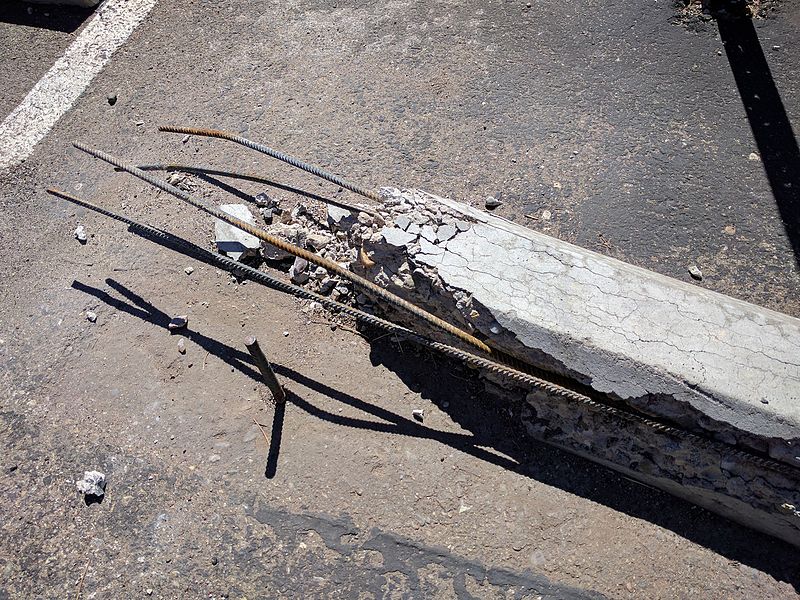 File:Broken concrete parking chock with exposed rebar.jpg