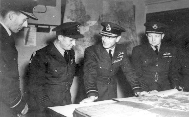 Air Vice-Marshal Ralph Cochrane, Wing Commander Guy Gibson, King George VI and Group Captain John Whitworth discussing the Dambusters Raid in May 1943