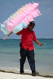 A man sells cotton candy to tourists on a beach in Cancun Cotton Candy Seller- Cancun Beach QR 2020.jpg