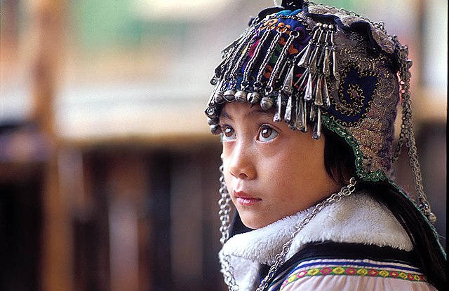 An ethnic Hani girl with a typical Hani headgear for children. Near Yuanyang, Yunnan Province, China.