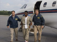 Registe being escorted by FBI agents after his extradition in July 2009. Extradition of Michael Registe.png