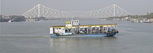 A ferry operating between Howrah and Kolkata with Howrah Bridge (Rabindra Setu) in background Ferry Howrah Bridge.jpg