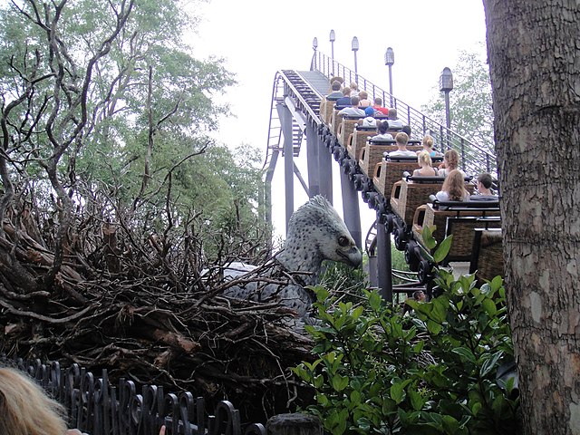 A vehicle ascending the lift hill on Flight of the Hippogriff. An animatronic Hippogriff can be seen in the background, to the left side of the lift h