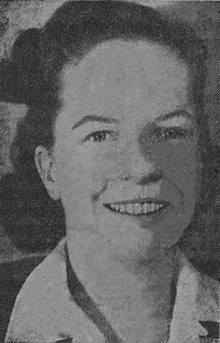 Photograph of a smiling young woman in a business suit