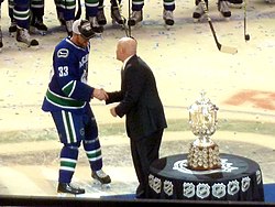 Henrik accepts the Clarence S. Campbell Bowl by deputy commissioner Bill Daly on behalf of the team as the 2011 Western Conference champions. Henrik Sedin Campbell Bowl crop.jpg