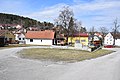 English: Village square in Krasetín, the Czech Republic, with the fire station (left of the centre) and the WWII memorial. Čeština: Náves v Krasetíně s hasičskou zbrojnicí (vlevo od středu) a pomníkem obětem nacismu.