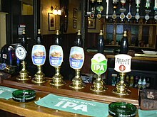 The six hand pumps inside the Lewes Arms in May 2007. Three are for Harvey's Best, two for Greene King products, and one for a cider. Lewes Arms handpumps.jpg