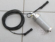 A wire antenna kit, with a coil of wire, strain insulators and a balun. When installed the wire is supported by buildings or trees using the insulators to prevent a short circuit to ground. Long-wire-and-balun-0a.jpg