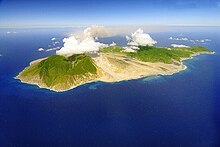 Aerial view of Montserrat from the south-east, showing (right) the Centre Hills and the inhabited northern end of the island, and (left) the Soufriere Hills, with the ash plume being emitted from the volcano MontserratWestIndies.jpg