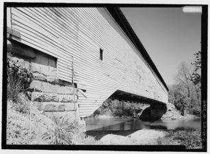 OBLIQUE VIEW FROM SOUTHEAST LOOKING NORTHEAST. NOTE CORNERSTONE IN ABUTMENT. - Jackson Covered Bridge, Spanning Sugar Creek, CR 775N (Changed from Spanning Sugar Creek), HAER IND,61-BLOMD.V,1-5.tif