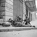 Paras from 5th (Scots) Parachute Battalion, 2nd Parachute Brigade, take cover on a street corner in Athens during operations against members of ELAS, 6 December 1944. NA20515.jpg