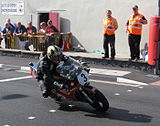 Michael Dunlop (3) Suzuki — Formula 1 Classic TT 2013 - Lap 3 Parliament Square, Ramsey 26 August 2013