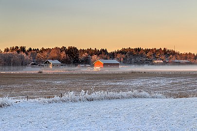 Red barn in winter mist in Brastad