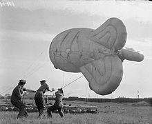 British military auxiliaries handle a barrage balloon.
