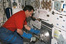 CNES astronaut Michel Tognini works with a nitrogen freezer, which supported the Plant Growth Investigations in Microgravity (PGIM) and Biological Research in Canisters (BRIC) experiments on this mission which took place in 1999 STS-93 Shuttle Mission - Michel Tognini.jpg